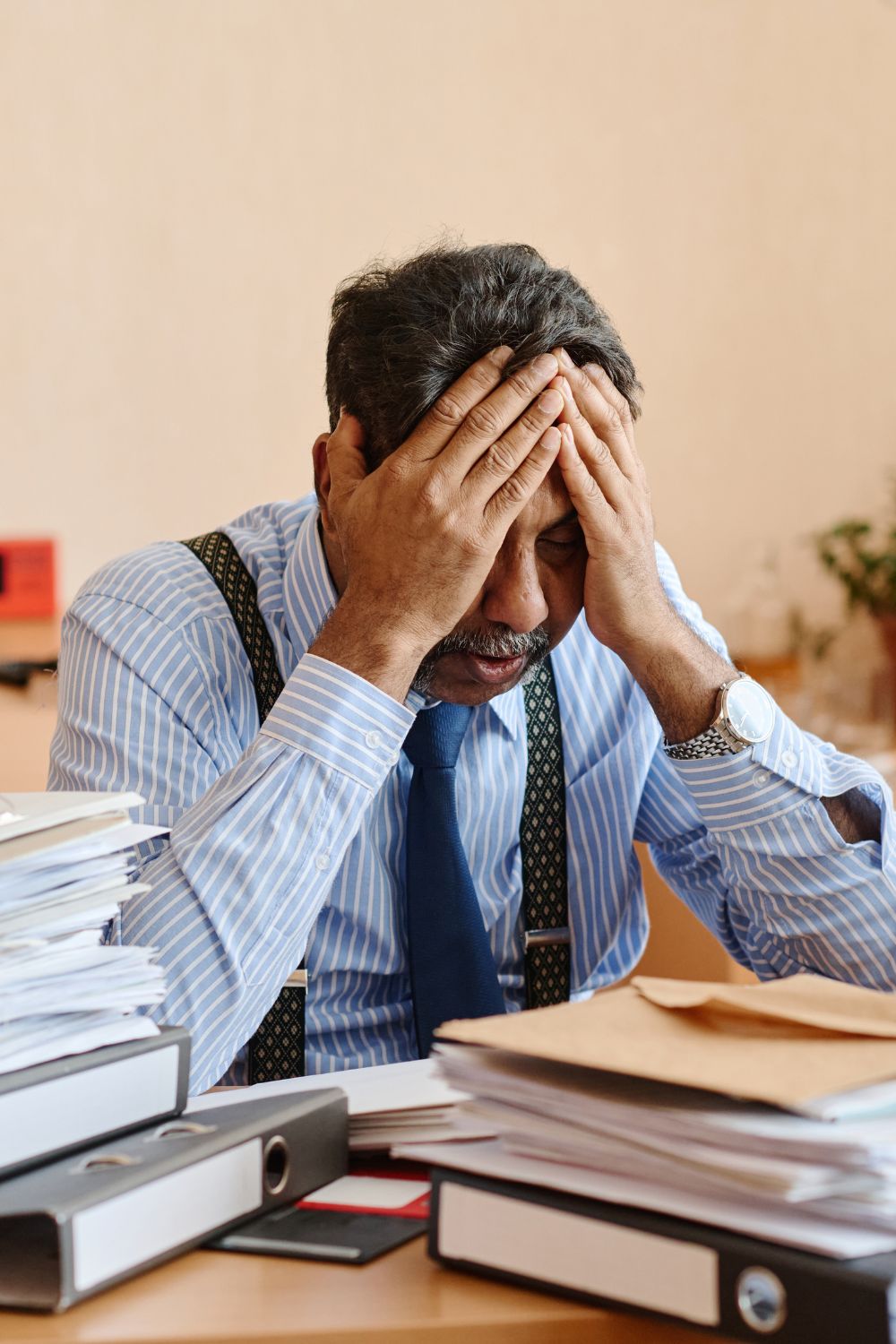 Overwhelmed entrepreneur surrounded by paperwork showing content creation frustration