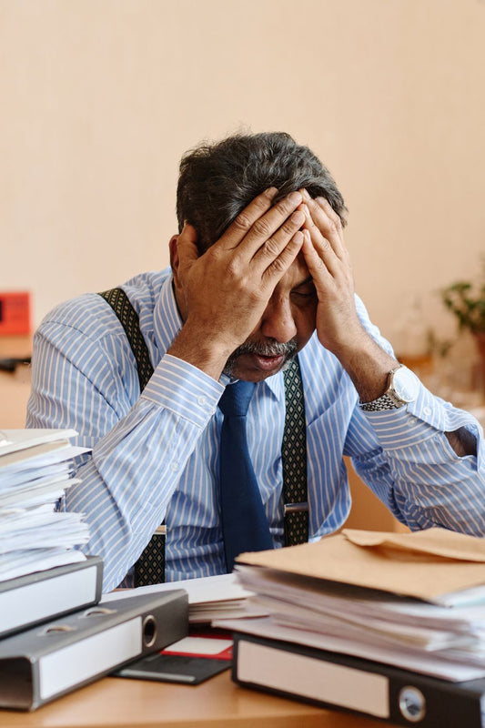 Overwhelmed entrepreneur surrounded by paperwork showing content creation frustration